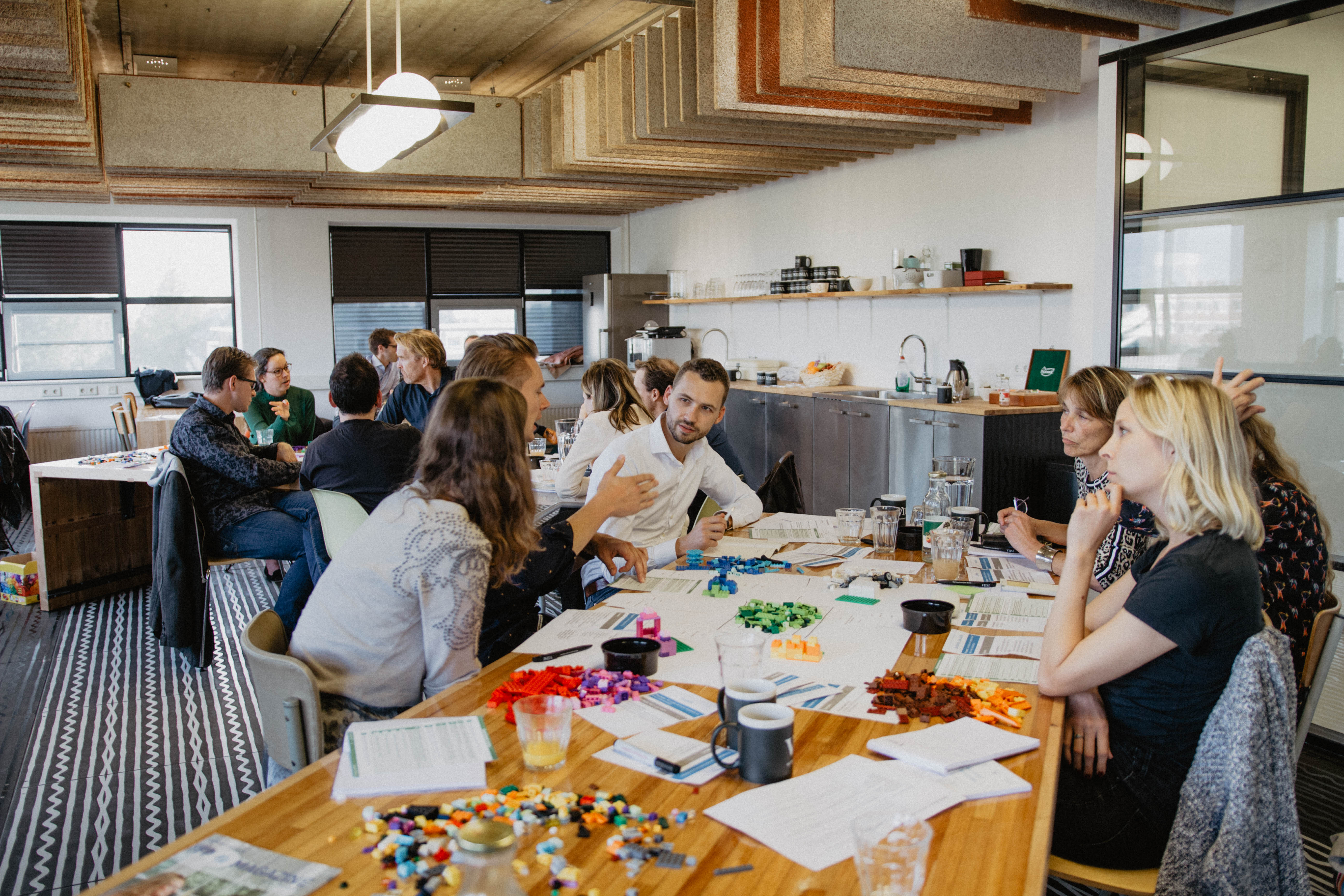 Team gathered around a table with colorful building blocks during a Teambooster team-building session