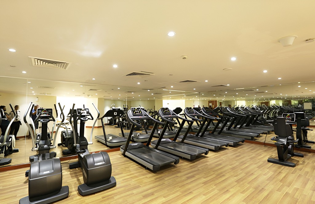 Interior of Lakeside Tower gym with multiple treadmills and reflective mirrors enhancing the workout space.