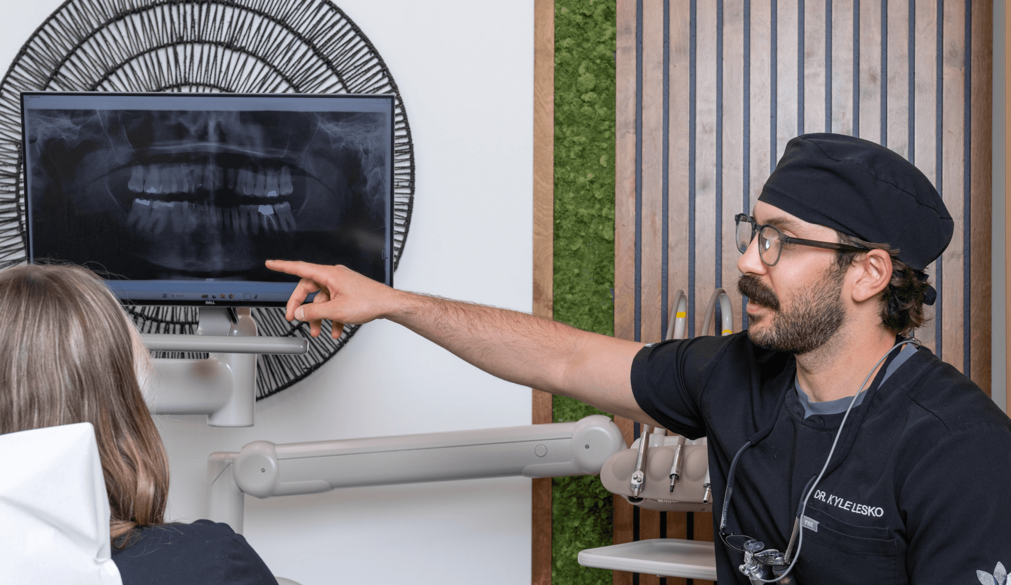 A dentist explaining findings using an on screen image