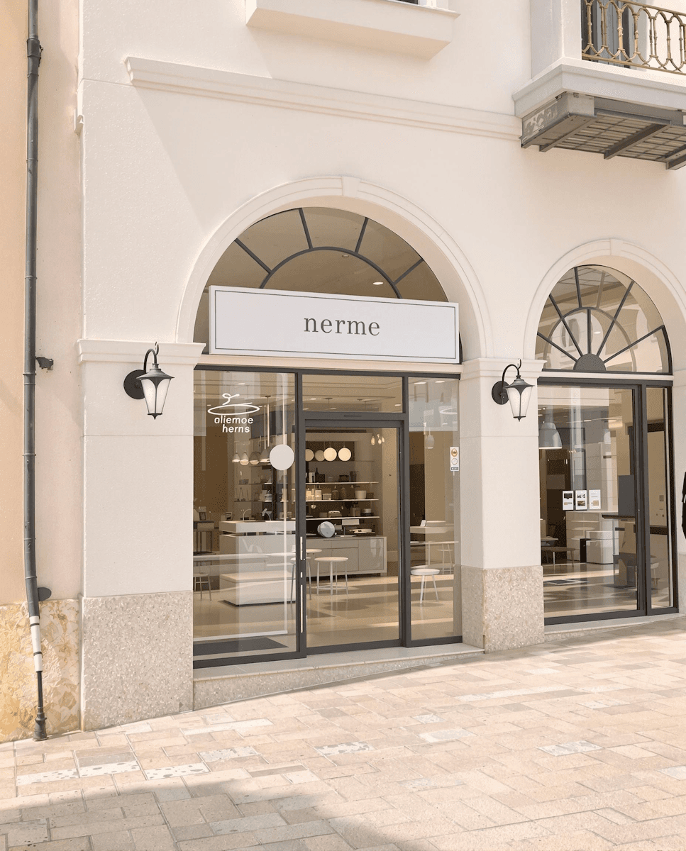 Retail storefront with arched entrance, glass doors, and a neutral-toned exterior facade.