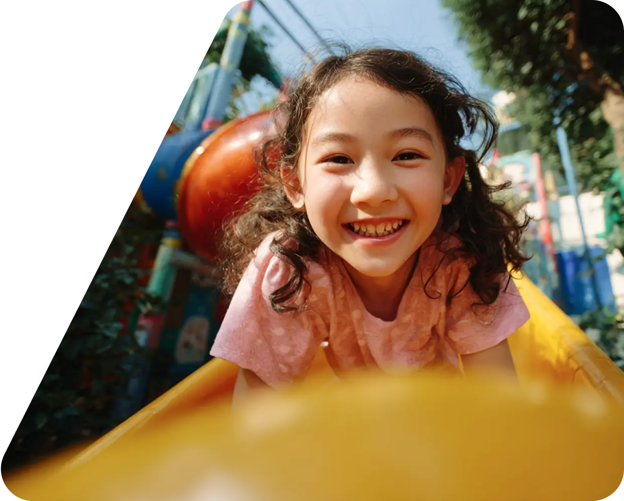 A joyful child smiles broadly, surrounded by iridescent bubbles in a sunlit garden, conveying a sense of happiness and playfulness.