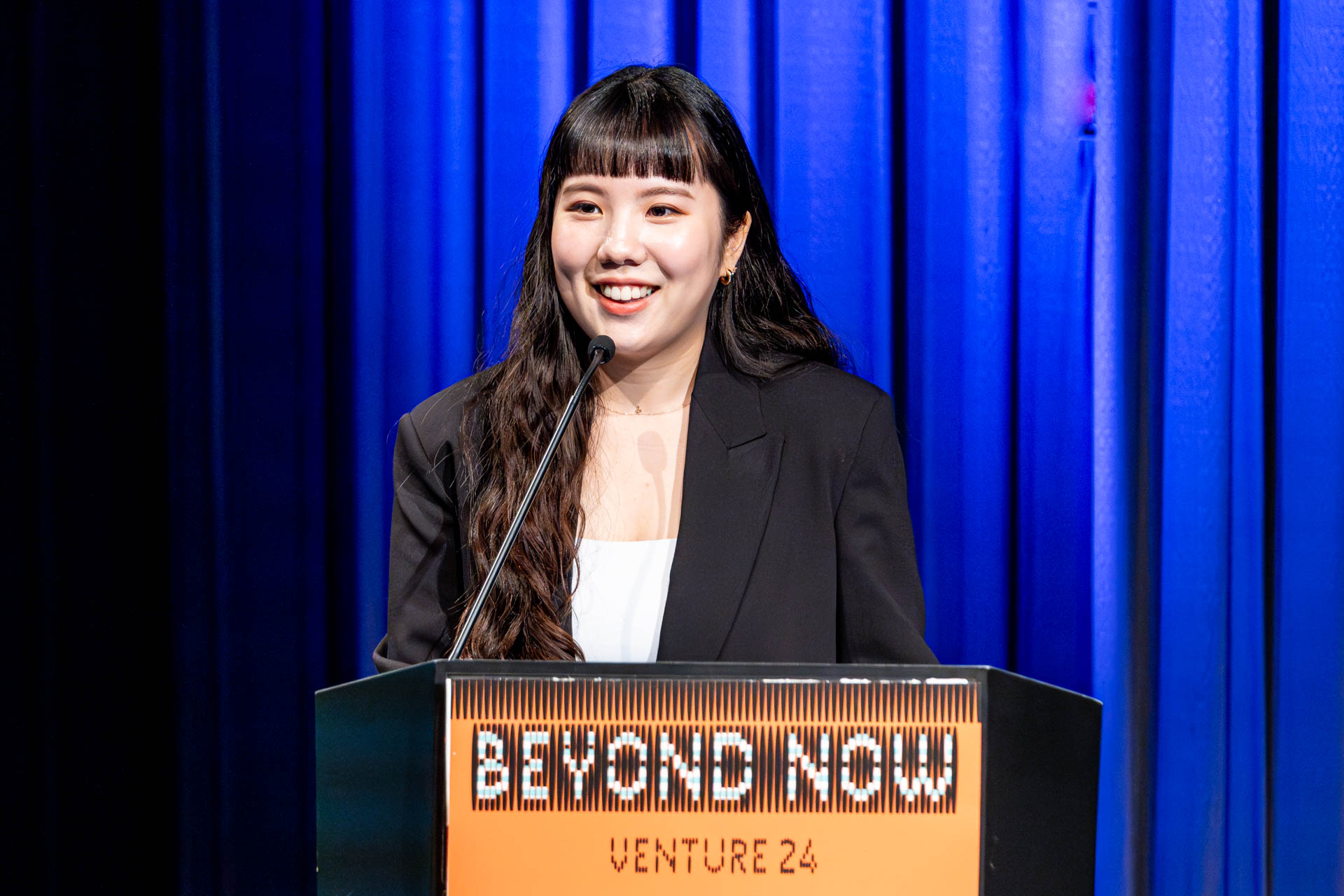 a student at a podium presenting a project in a Theatre