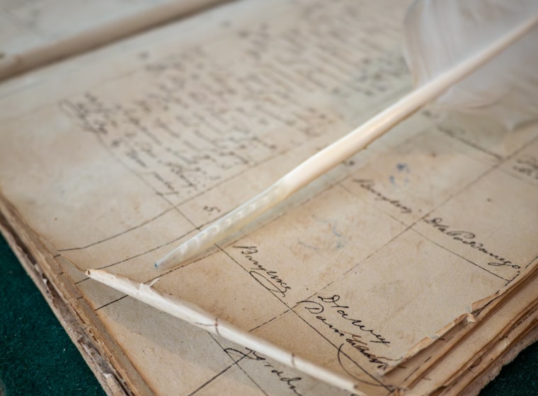 A pen resting on a handwritten ledger