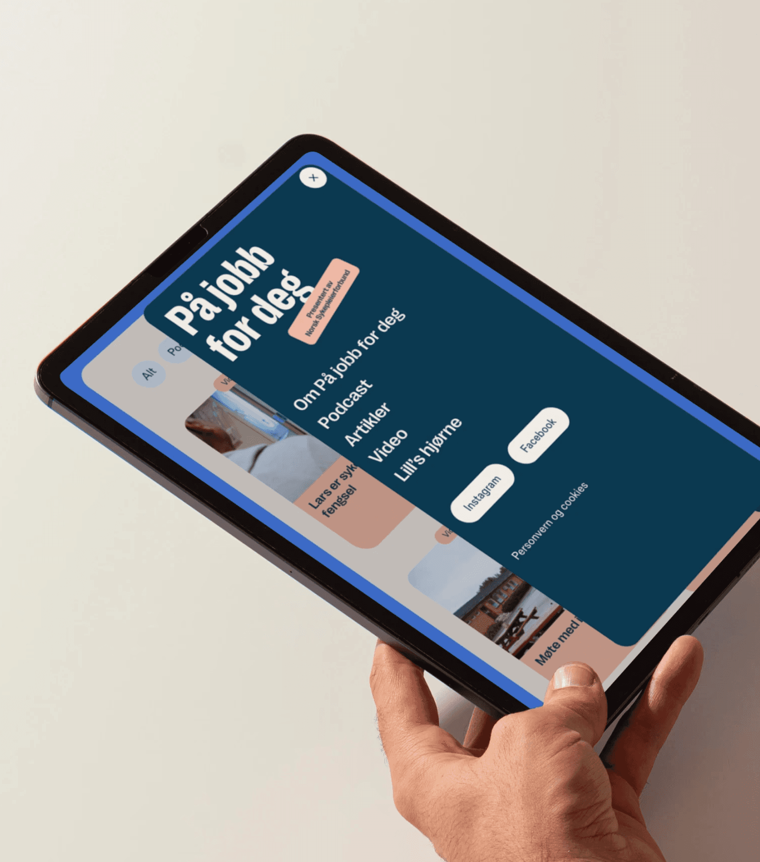 Hand holding an ipad displaying the website design for "På jobb for deg", featuring a user friendly layout.
