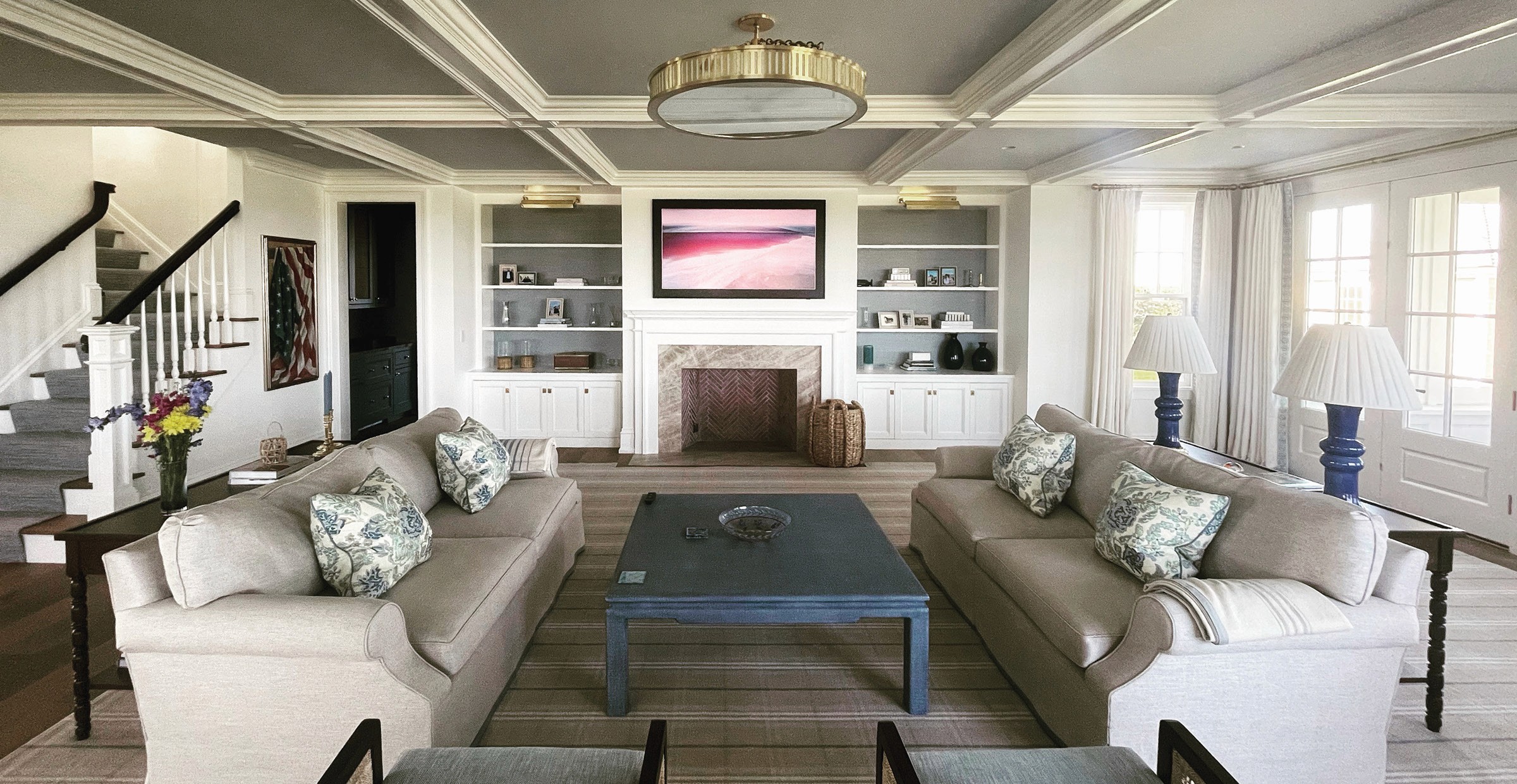 Living room with two sofas, fireplace, and painting