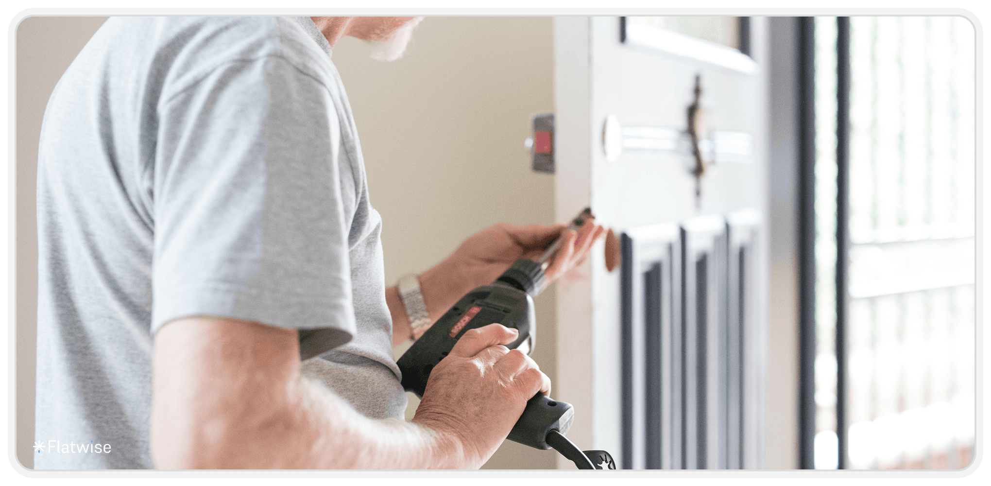 Foto von einem Hausmeister, der eine Türe repariert.