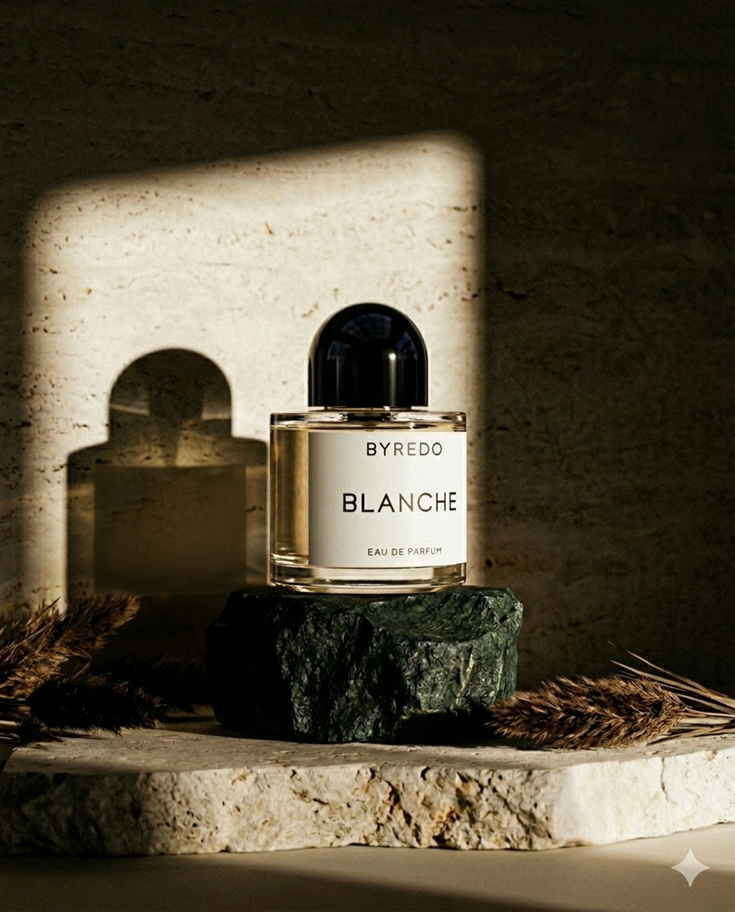 Parfum Byredo, sur socle en pierre avec une lumière apaisante.