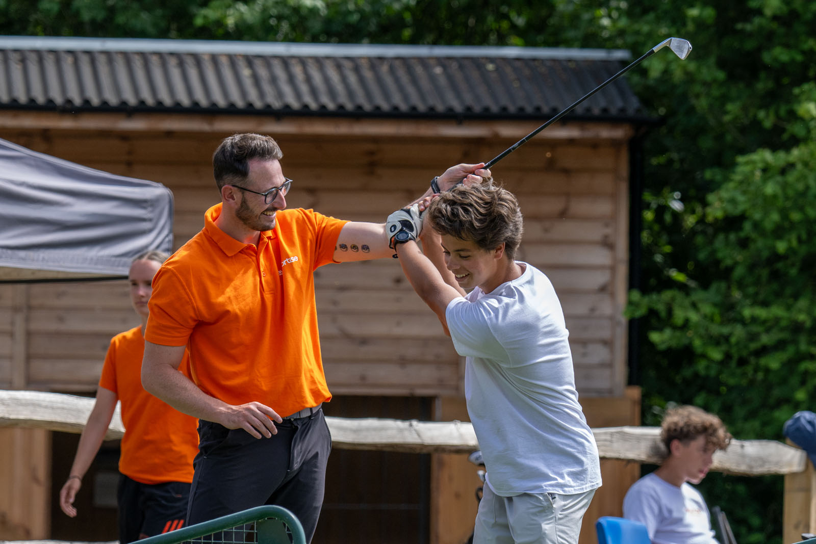 A golf coach correcting the swing of a student.