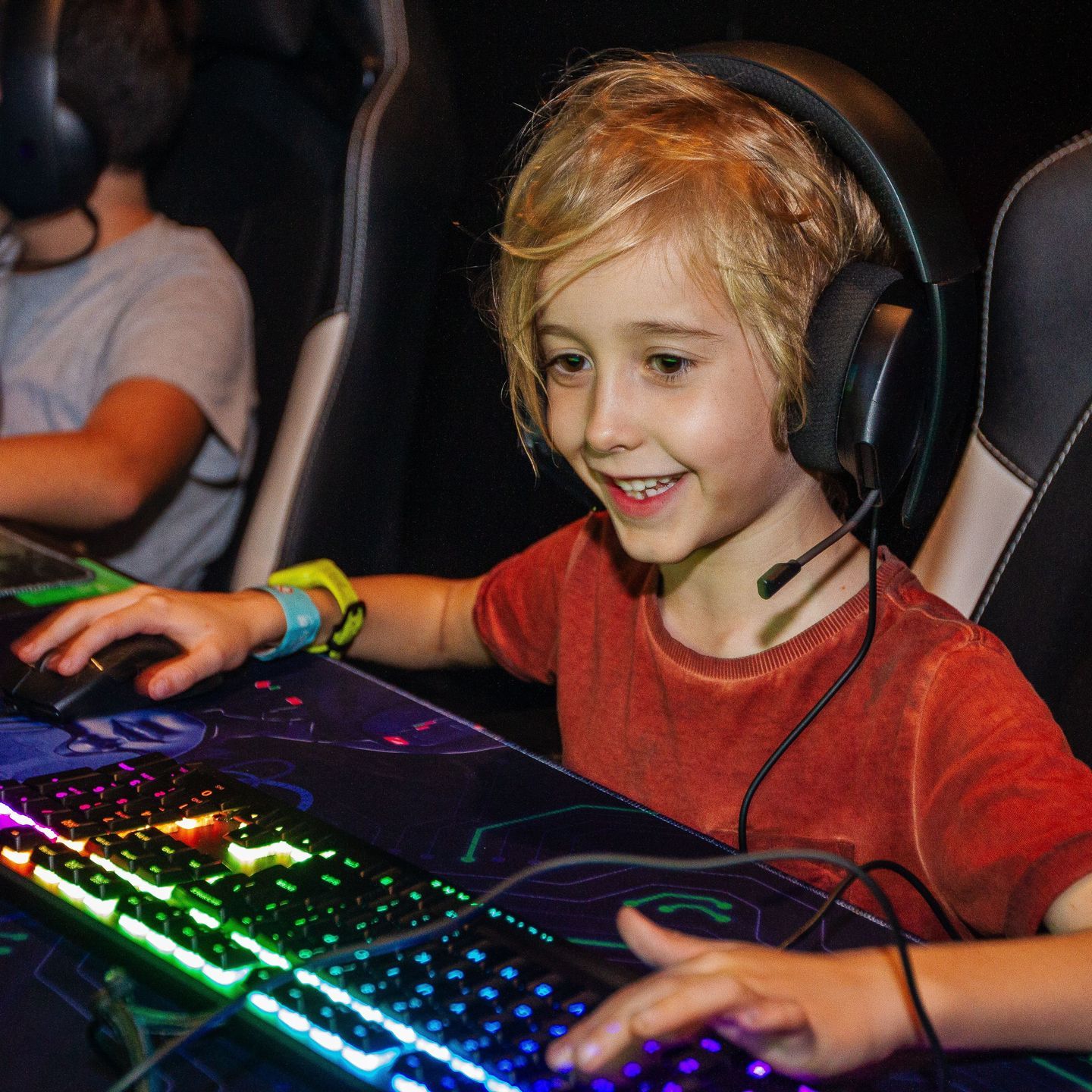A kid wearing headphones while sitting in front of a computer at Fortress