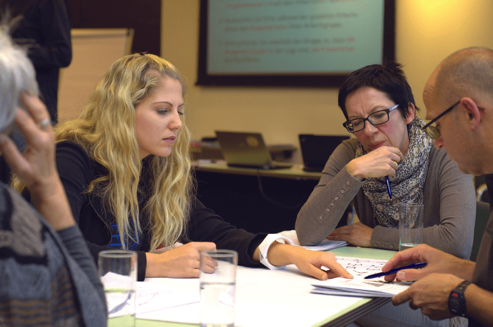 A diverse team of learning experts and stakeholders engaged in a collaborative meeting, discussing the design and development of an engaging custom eLearning curriculum.