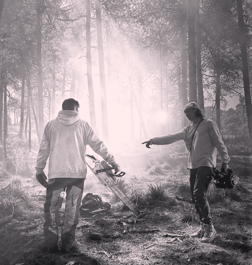 Black and white image of people working at a table with laptops, showing hands gesturing during discussion of digital content displayed on screens, with fabrica® logo in the corner.