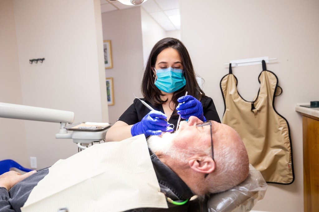 Dental hygienist performing teeth cleaning in Newark & Milltown NJ