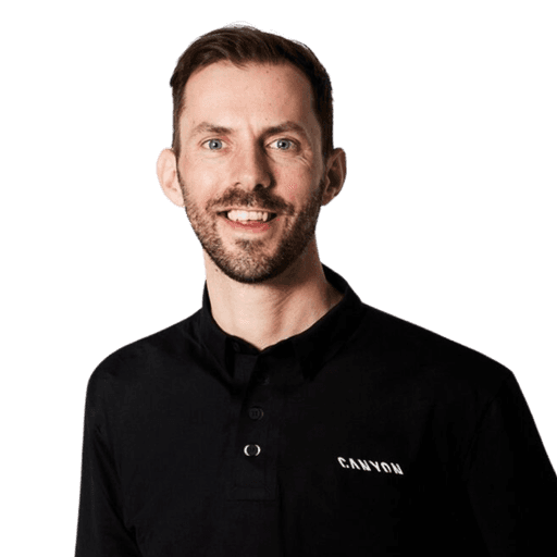 Headshot of a smiling man wearing a long sleeve black shirt