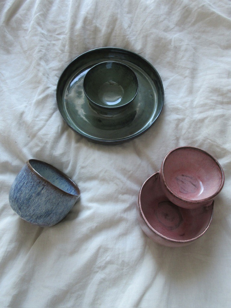 Dark teal ceramic lidded container with pink interior bowl