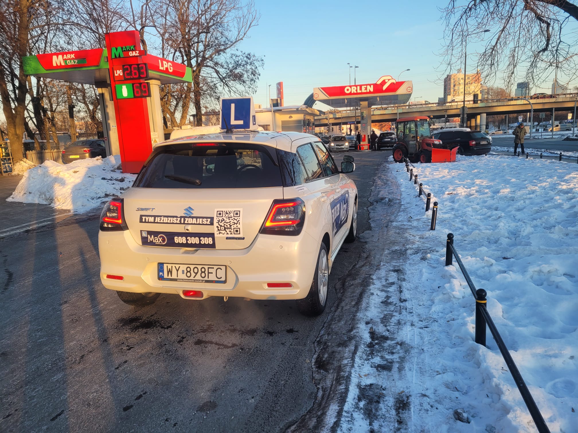 Two individuals are working out in a gym, focusing on dumbbells and strength training equipment.