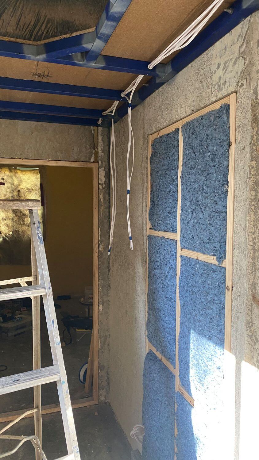 Genius denim insulation showing on the side of a house inside a timber frame, beautifully newly renovated area