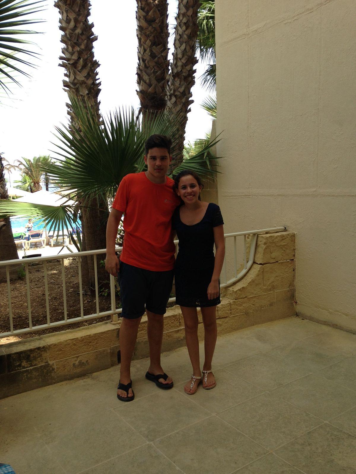 A bride and groom share a kiss, enveloped in the bride's flowing veil. The soft focus and gentle light convey a romantic, intimate atmosphere.