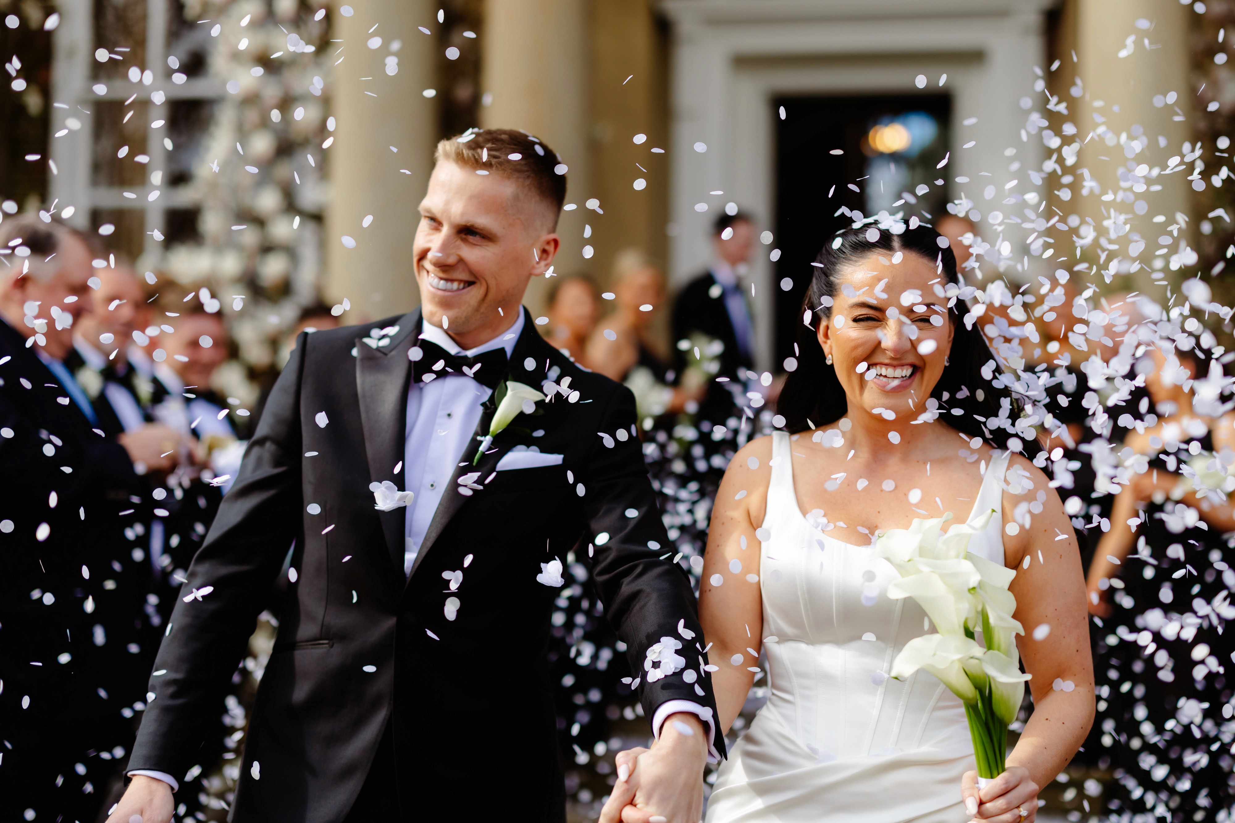 Olivia and Jake walking through confetti outside Iscoyd Park’s country house