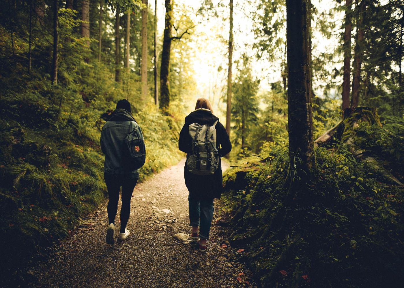 Two people with backpacks on walking in nature
