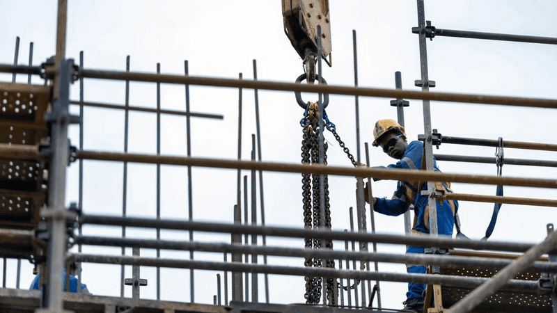 seven construction workers standing on white field