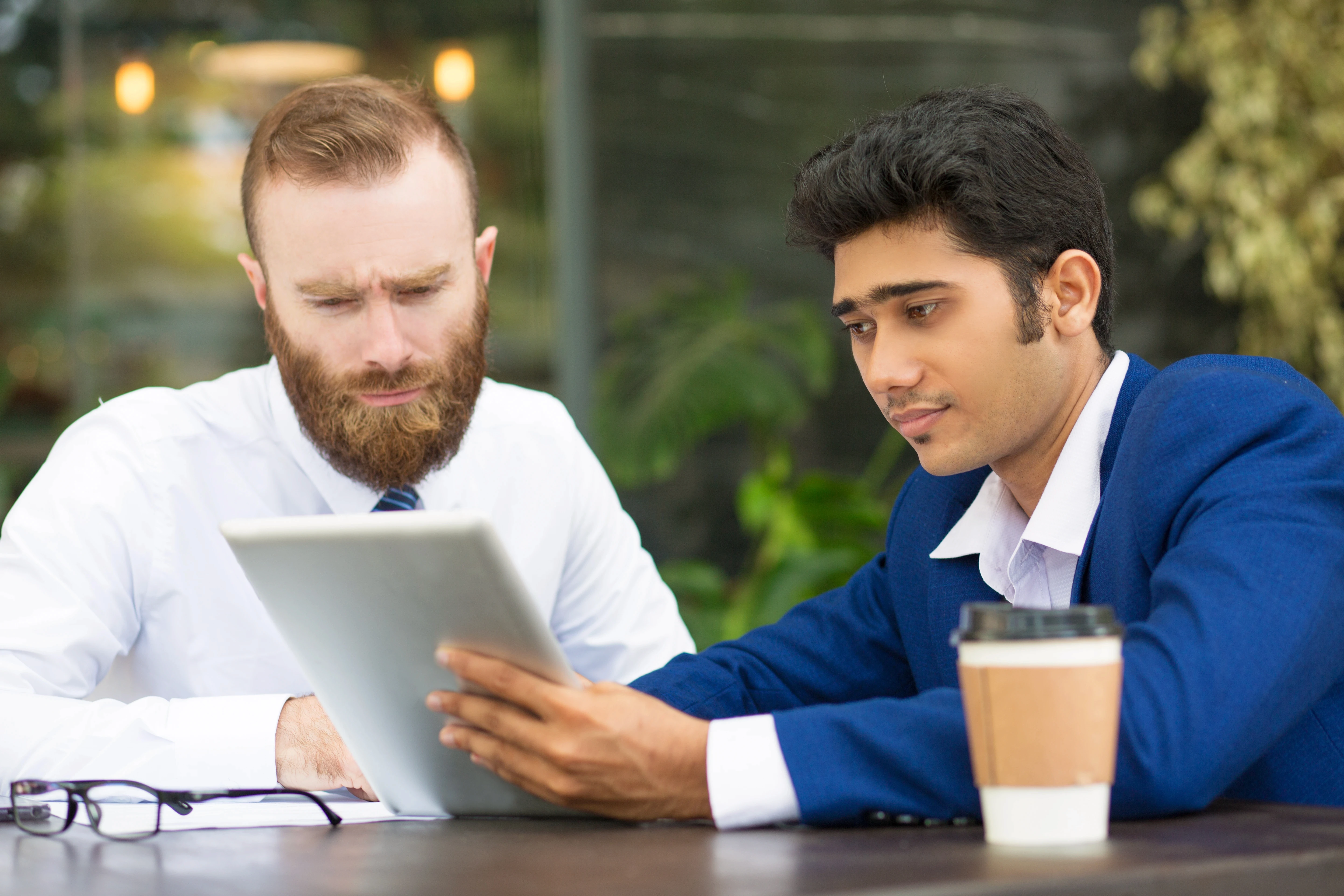 concentrated-multi-ethnic-business-partners-using-tablet
