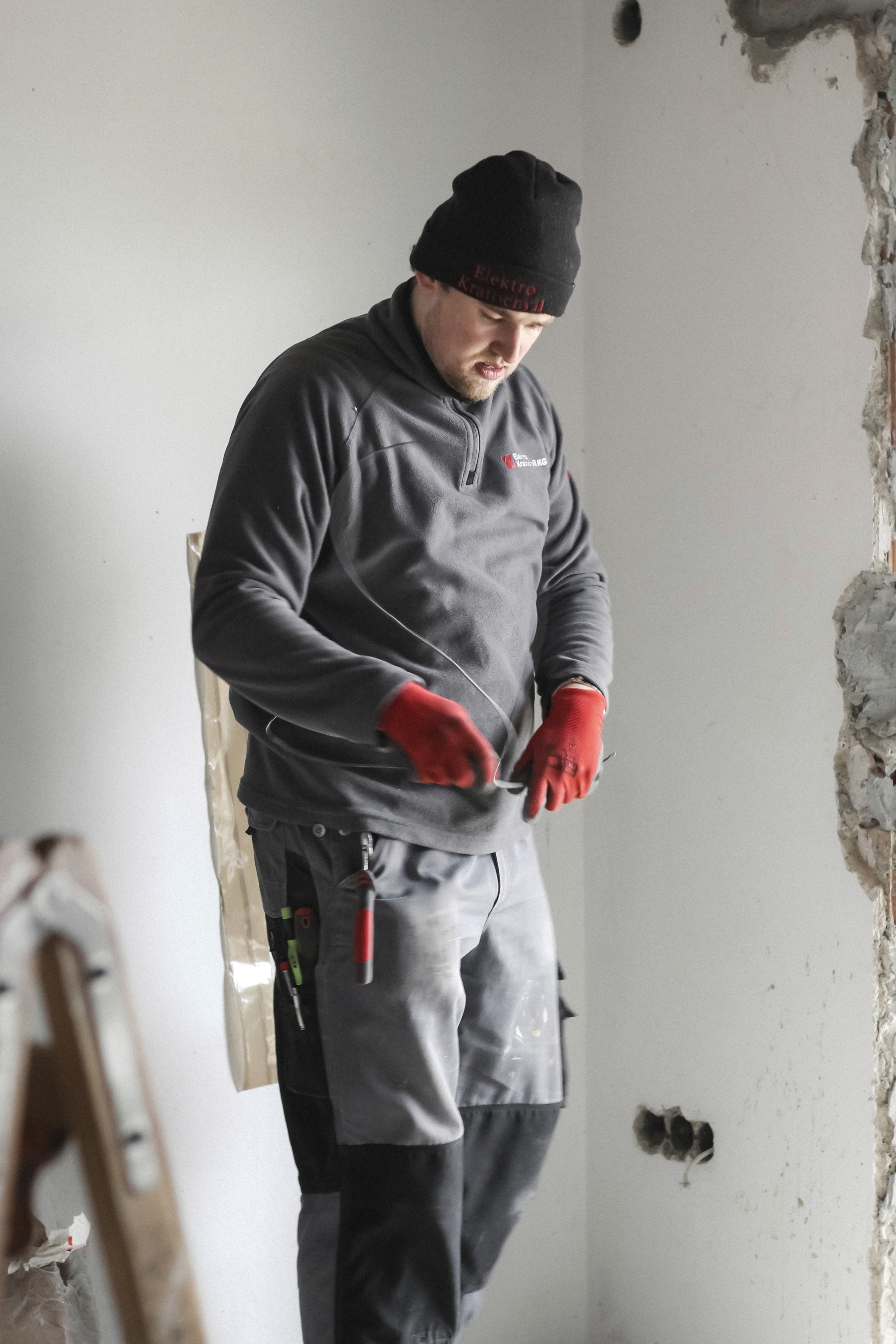 Elektriker von Elektro Kratochvil arbeitet mit Akkuschrauber mit Präzision und Sicherheit.