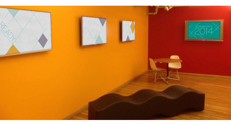 An art gallery rom with orange and red walls, some pictures with cube drawings on them, a small table with two chairs and a sofa in the form of a wave.