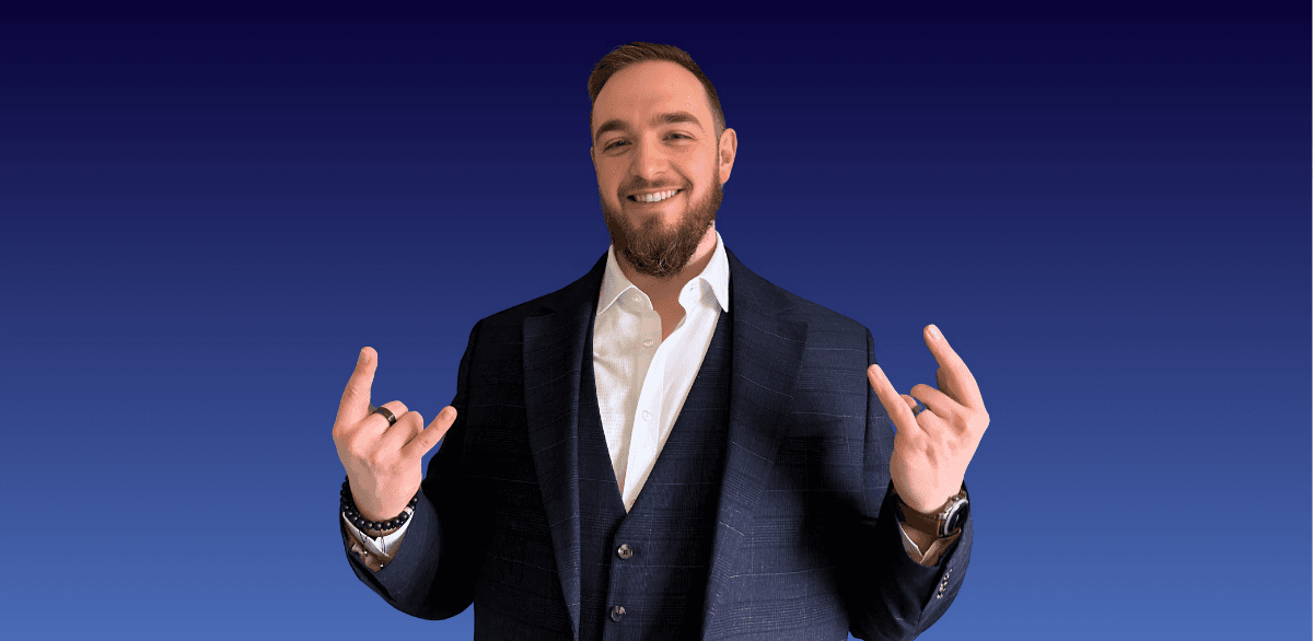 A man in a suit. He's smiling, has short hair and a beard