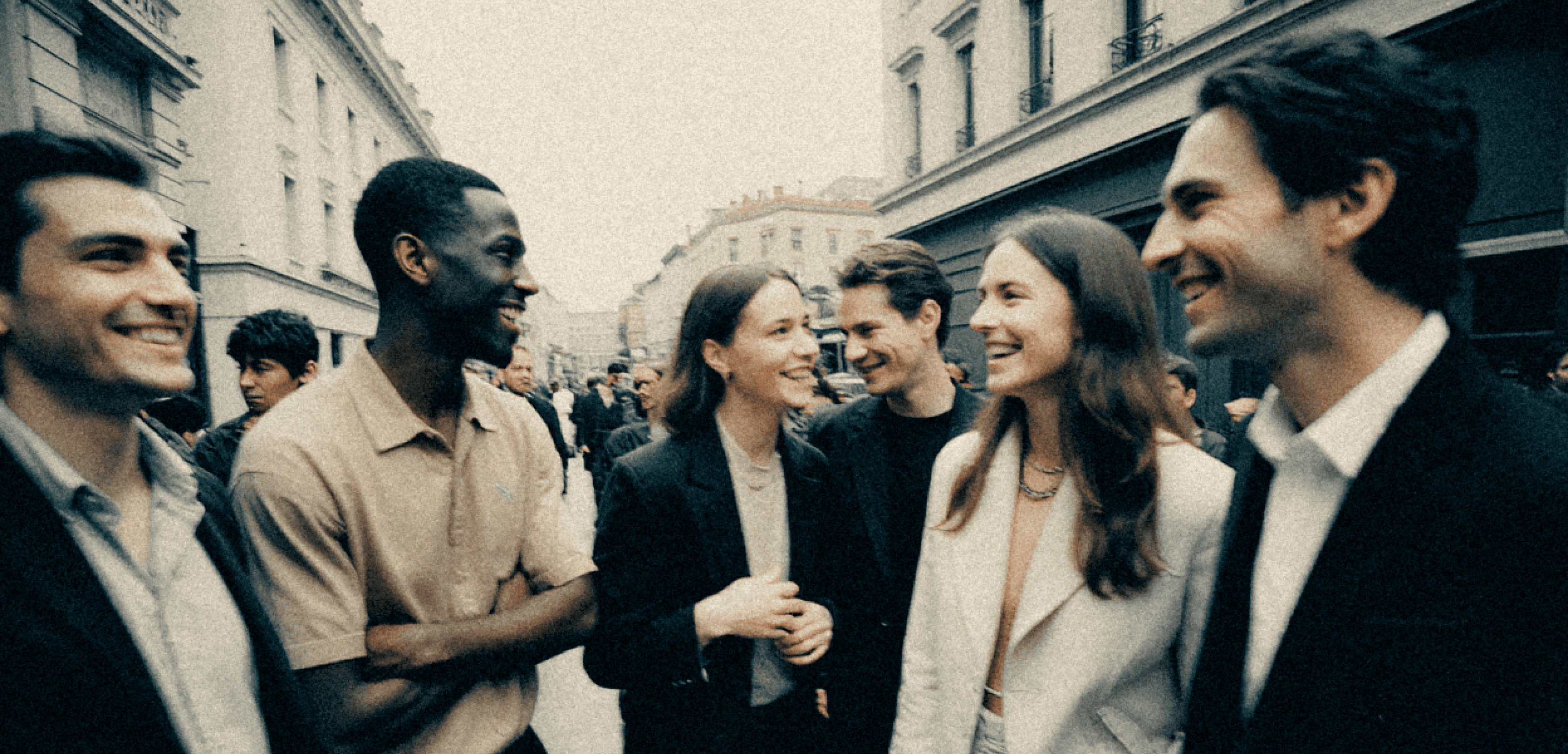 A group of male and female models in the middle a street standing in a group talking with each other