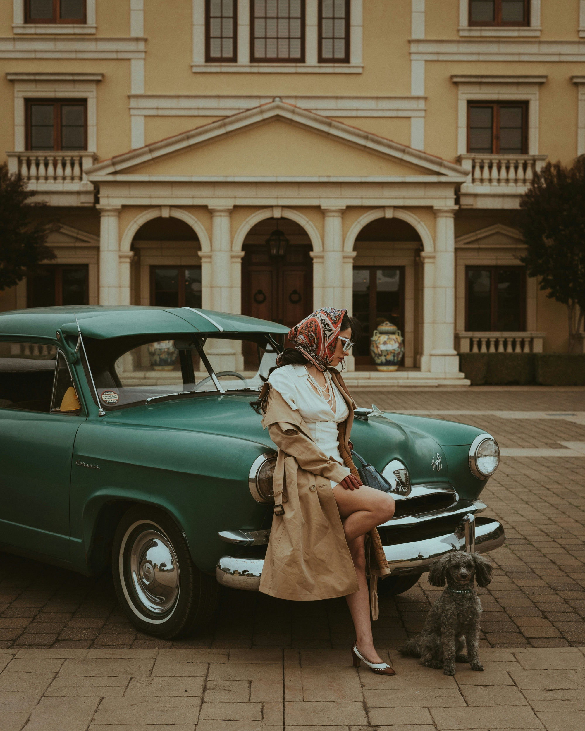 A woman standing next to a vintage car