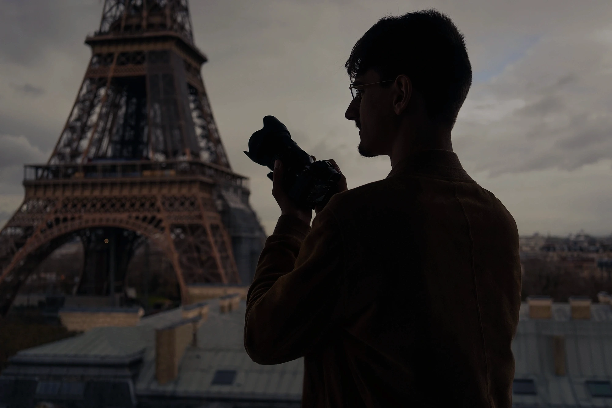 Collaborative work session overhead view of six people collaborating at a rustic wooden table with coffee, papers, and a laptop