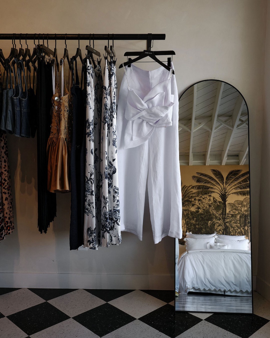 Forte Deux boutique clothing rack with curated garments and full-length mirror inside fashion retail store.