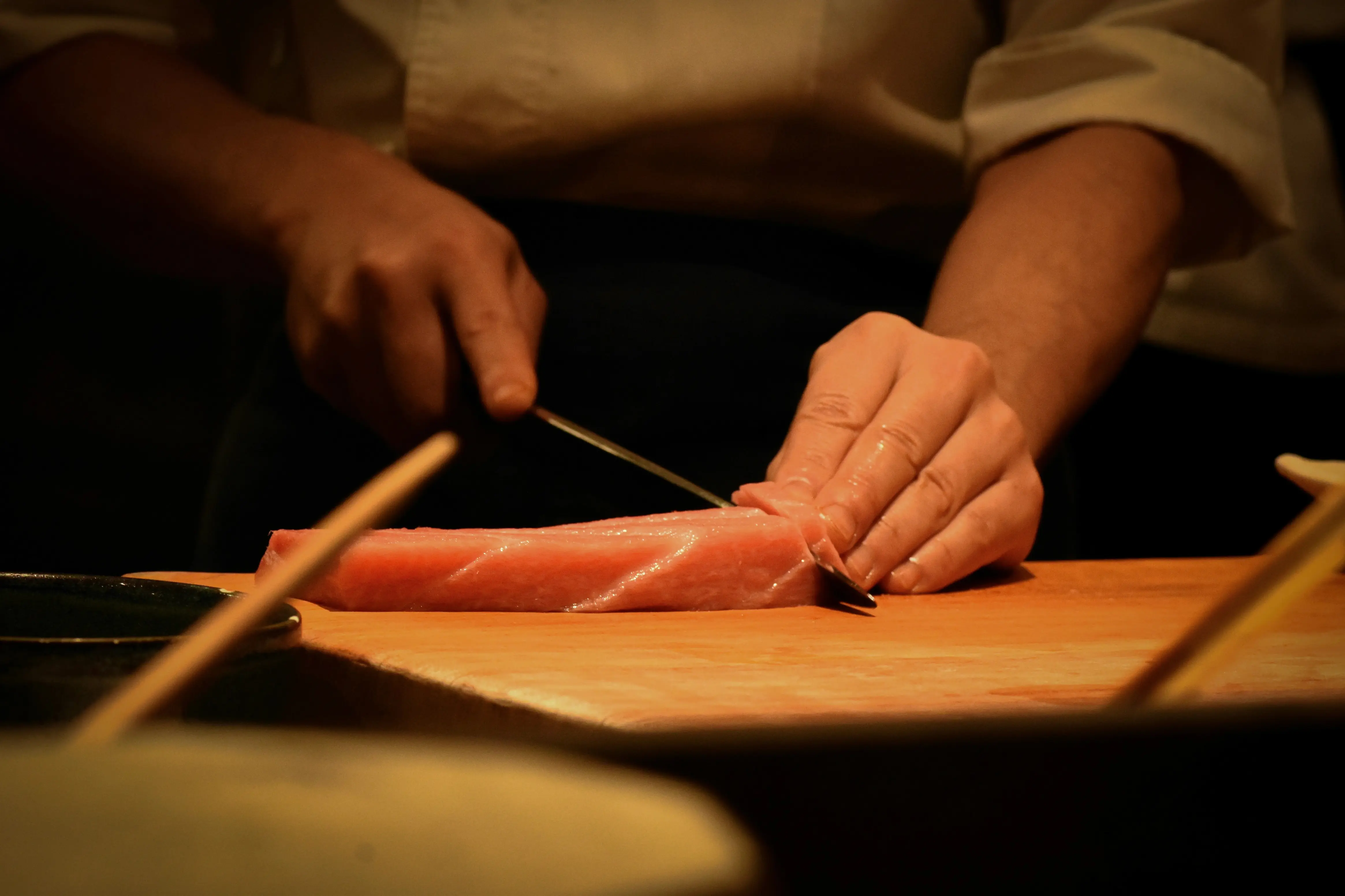 a person cutting up a piece of meat on a cutting board