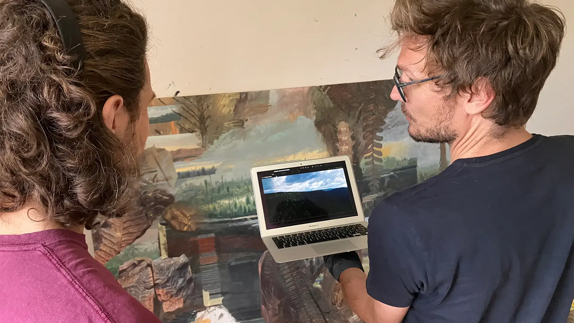 Dvojice tvůrců při práci nad notebookem. Dokumentace cesty za inspirací a vznik výsledného díla.