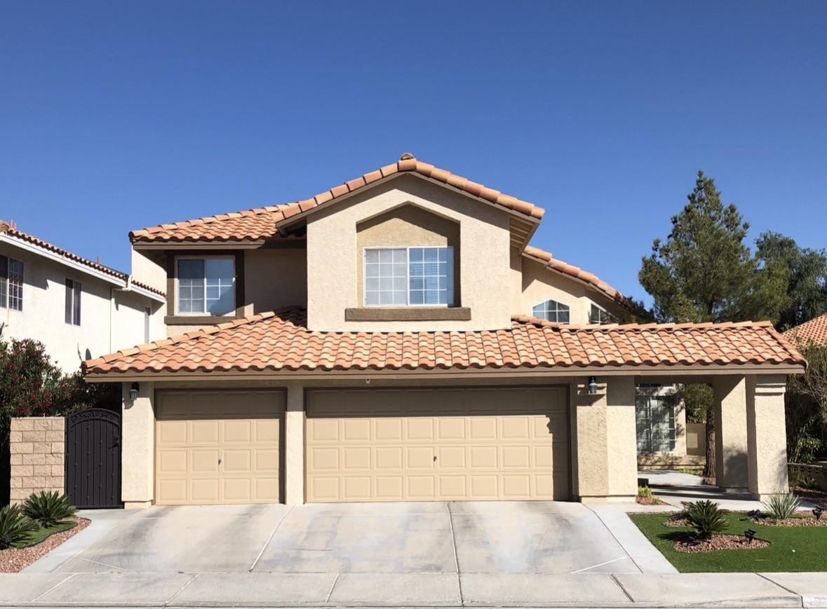 The original front yard — beige stucco, sparse desert landscaping, no personality