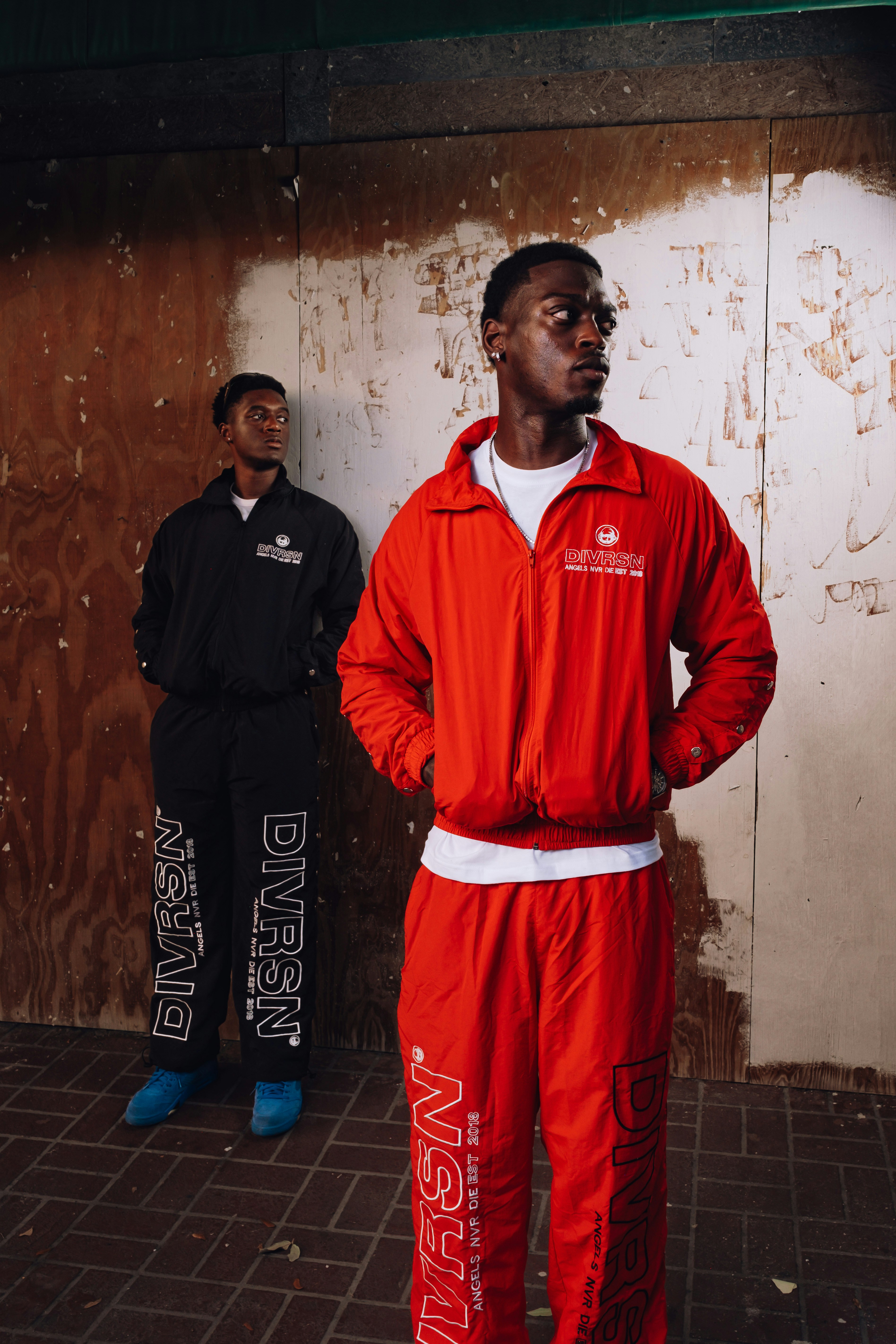 Two men in matching red and black athletic wear.