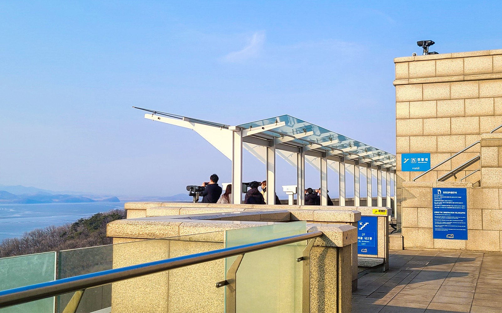Observation deck overlooking the DMZ with tourists using binoculars, Paju, South Korea.