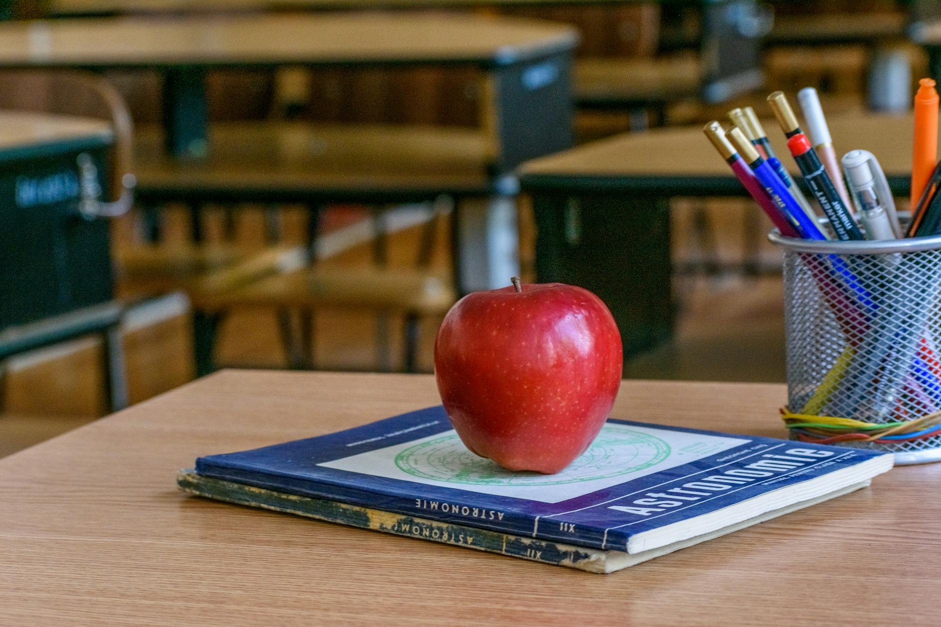 A teacher organizes colorful sticky notes and printed reading passages on a wooden table to prepare a lesson plan.