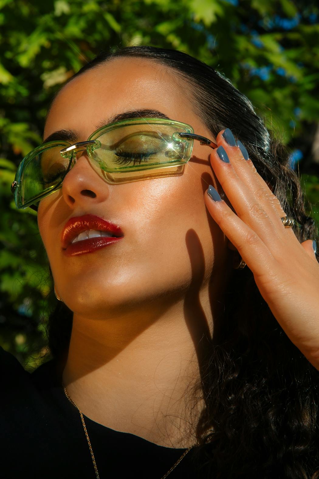 Fashionable woman posing outdoors in sunglasses