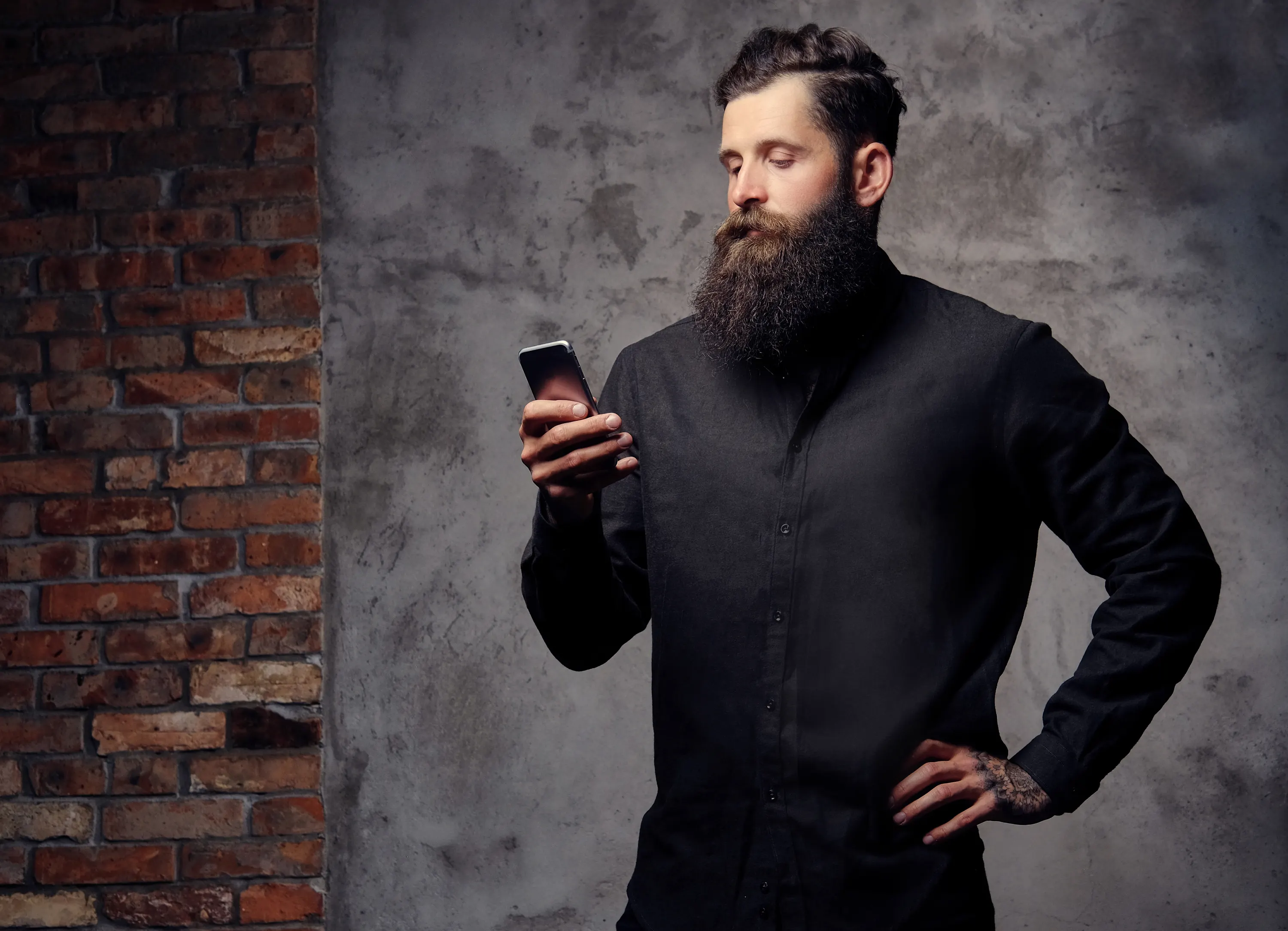 homem de gola alta preta segurando smartphone com postura confiante
