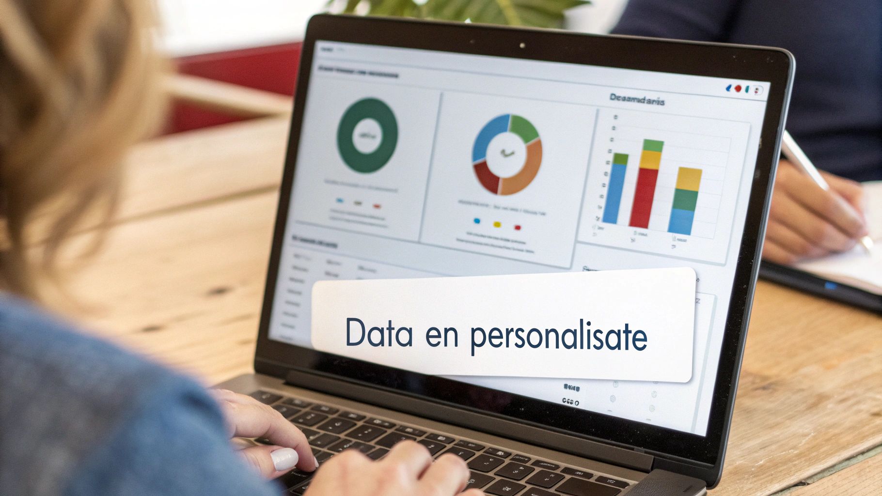 Vrouw typt op laptop met datadashboards, waarop 