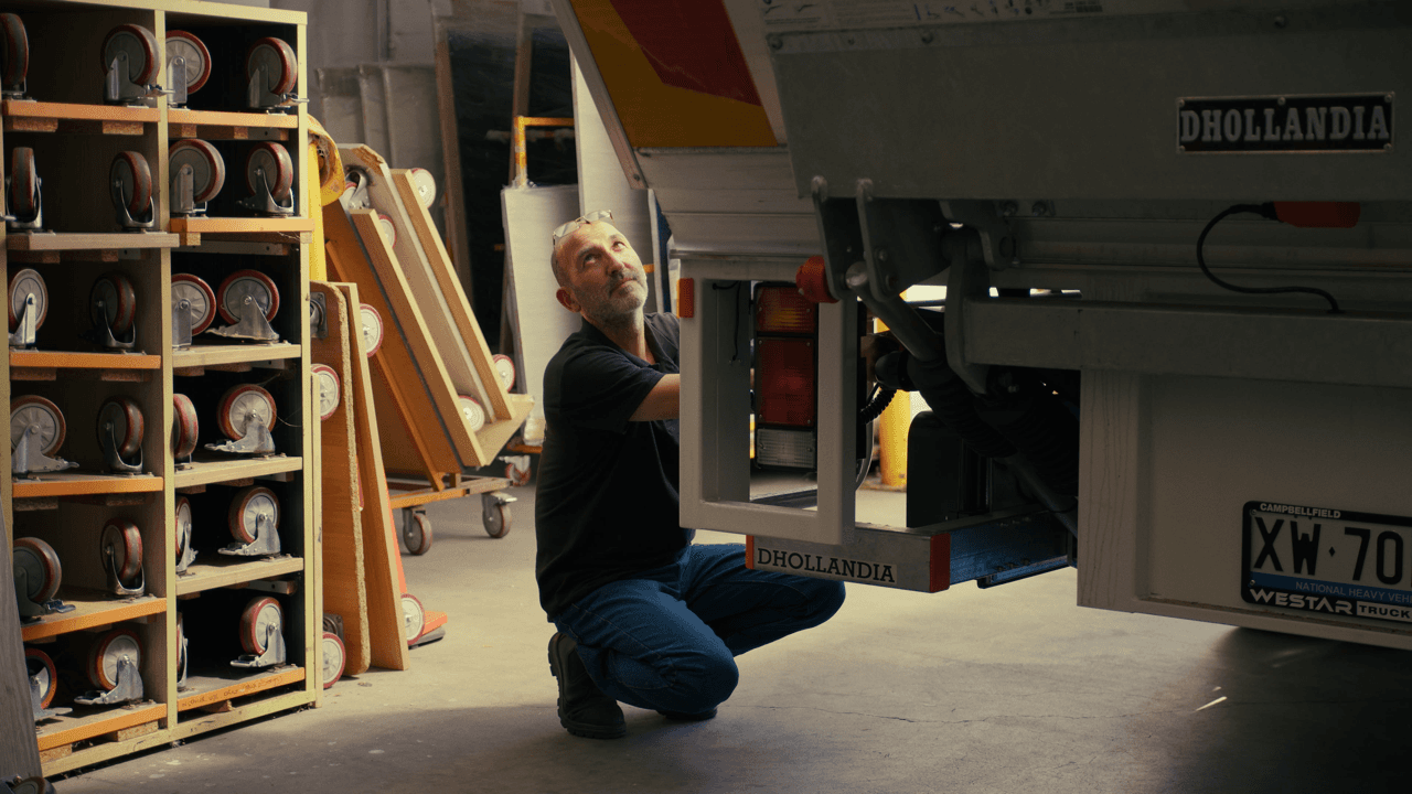 Interior of a storage area with various items on shelves and a man filling a truck