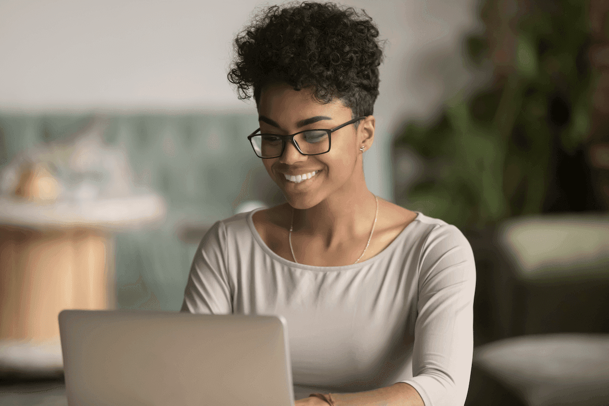 sales management software: woman happily working on his laptop