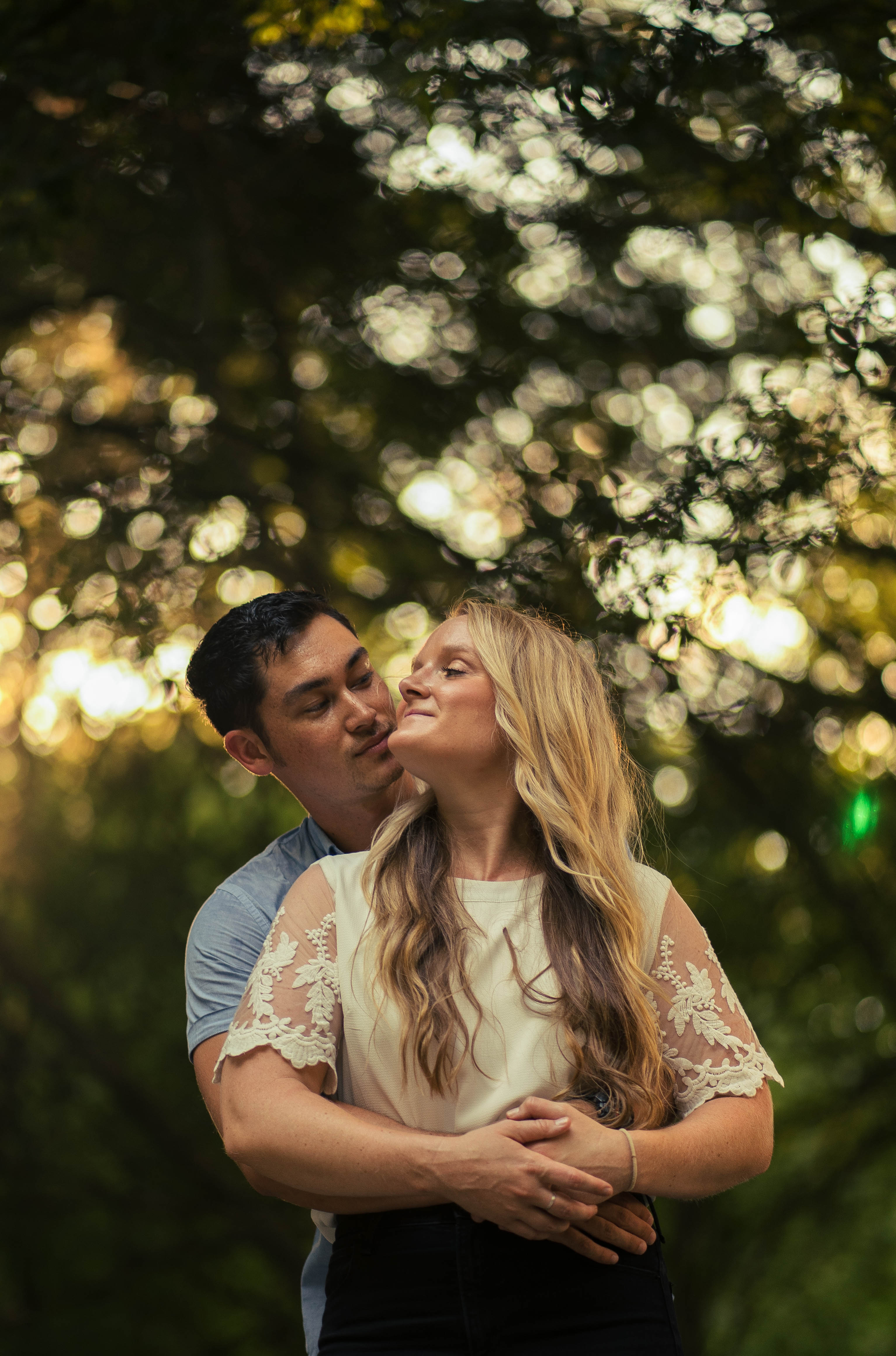 A couple stands outdoors at sunset.