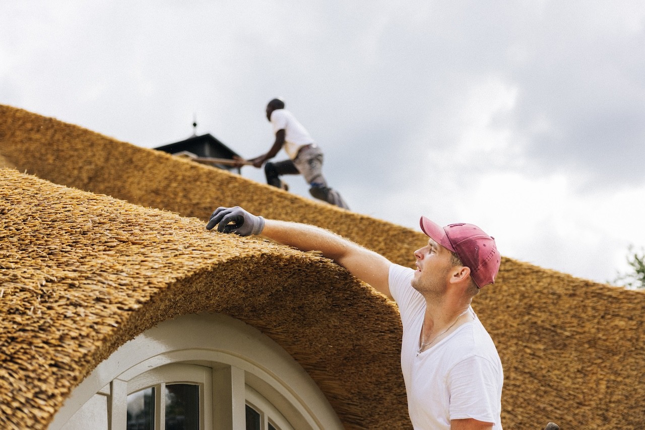 Rietdekkers van Rietdekkersbedrijf van Dijk Putten aan het werk op het dak