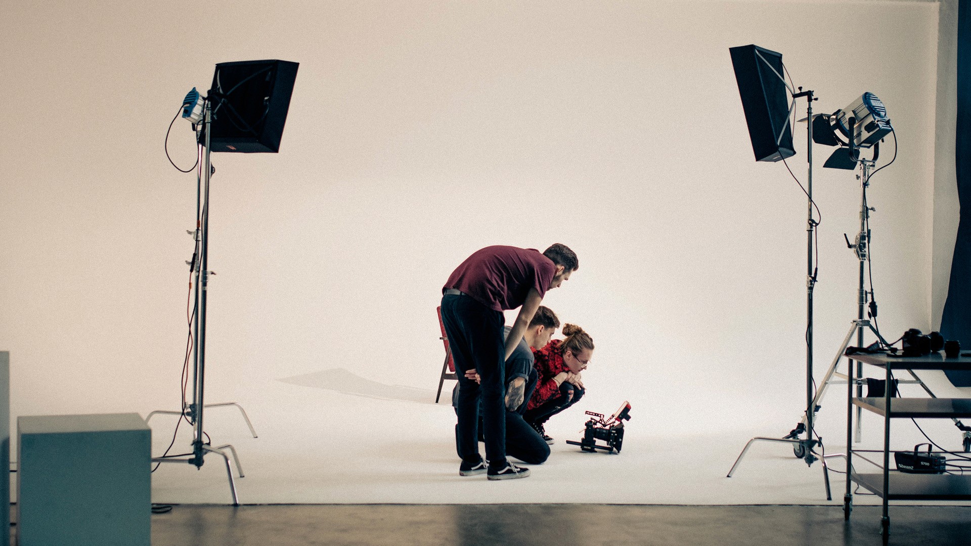 A thoughtful young person with dark hair gazes to the side, captured in soft black and white lighting.