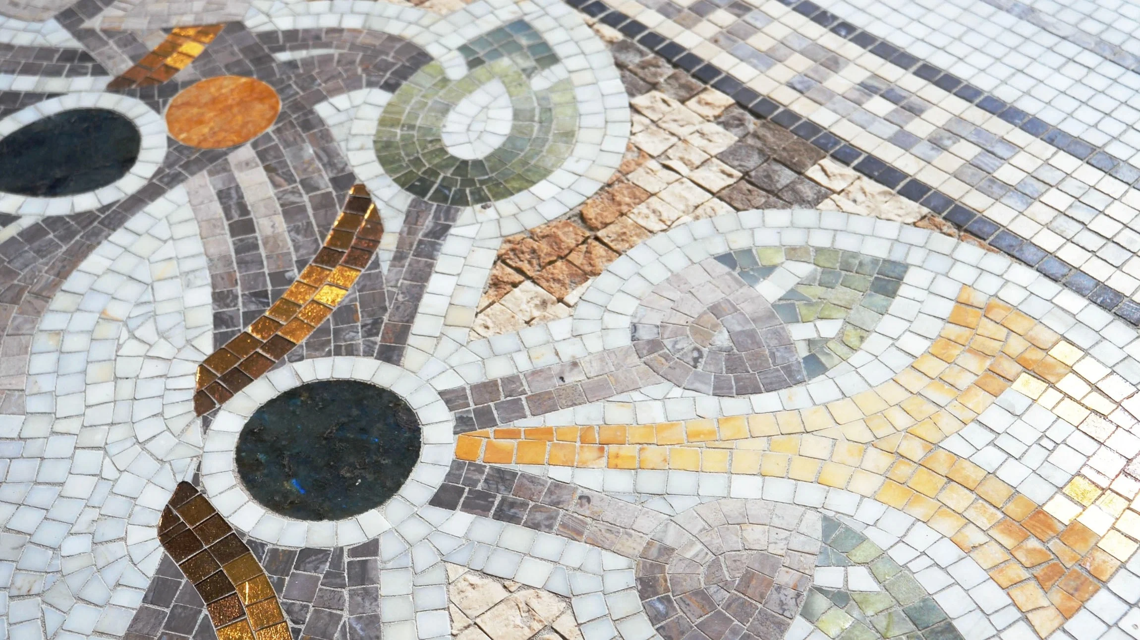Artisan hand-cutting mosaic tesserae for a bespoke surface
