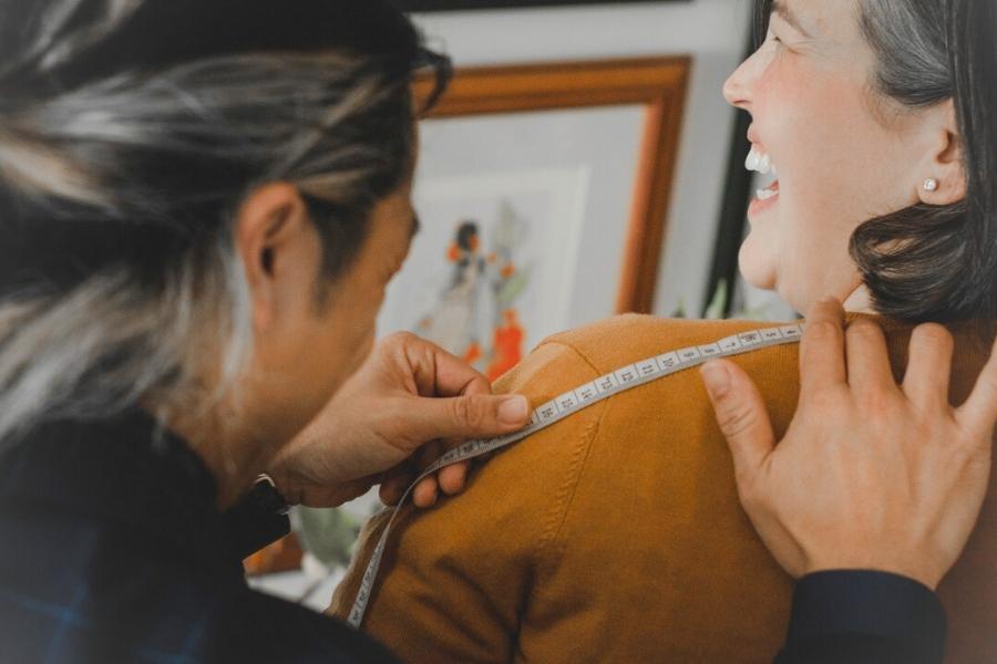 Isadora Nim photo where Peter founder of Isadora Nim measures his client for a custom bespoke ladies suit