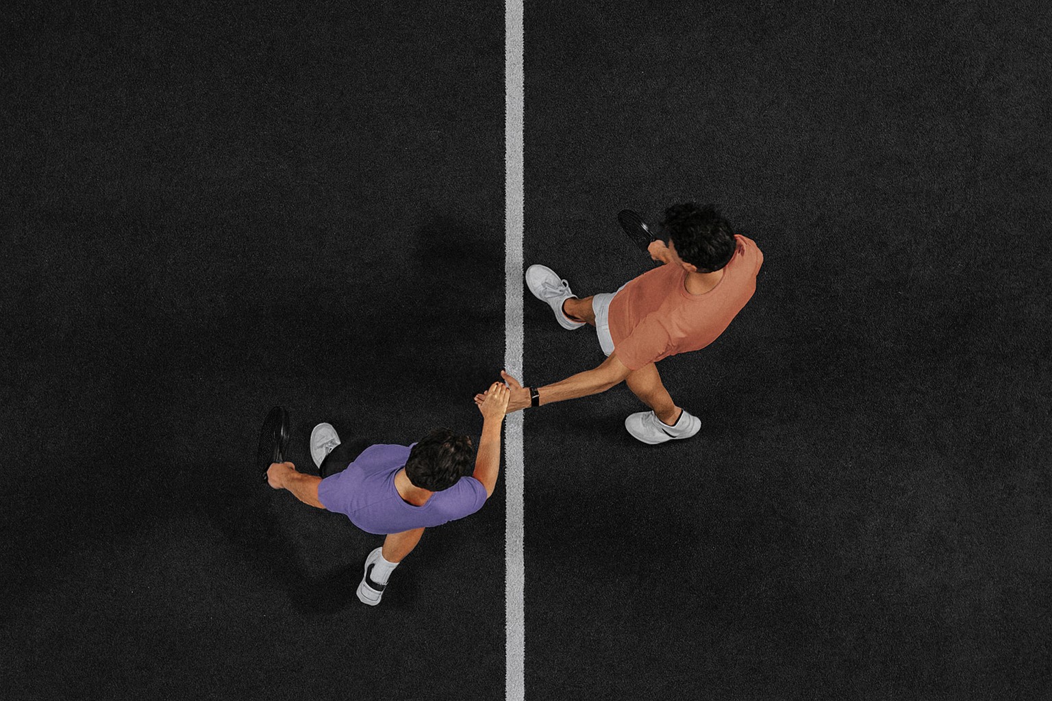 Zwei Padelspieler geben sich nach dem Match die Hand über das Netz – ein Symbol für Fairplay, Respekt und Community auf dem Padelnero Court