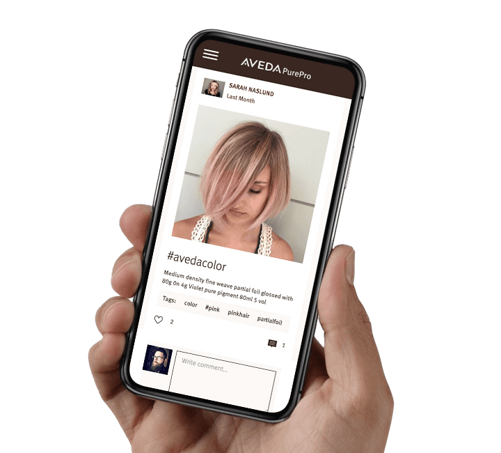 Hand holding a new iphone with Aveda PurePro App on screen.